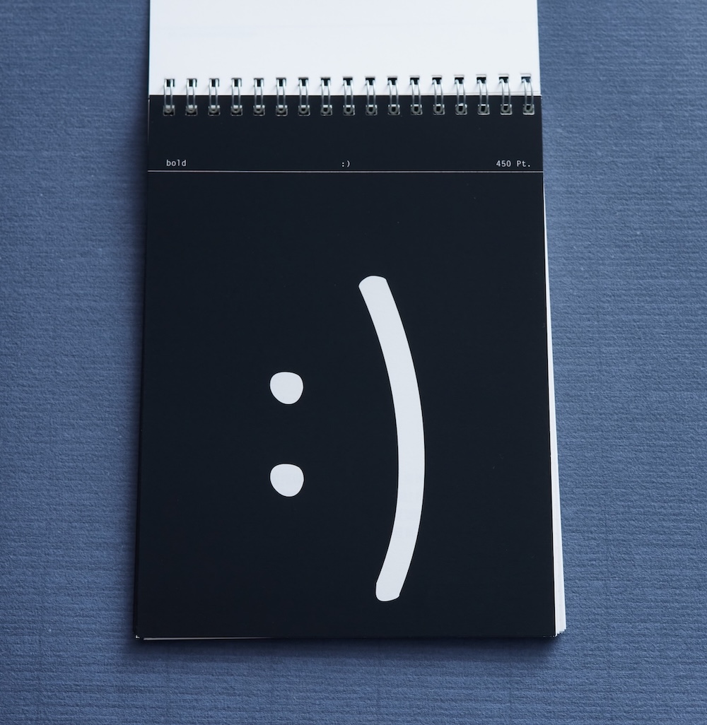 Specimen mit aufgeschlagener Seite. Diese Zeigt :) Im schriftschnitt bold auf schwarzem hintergrund