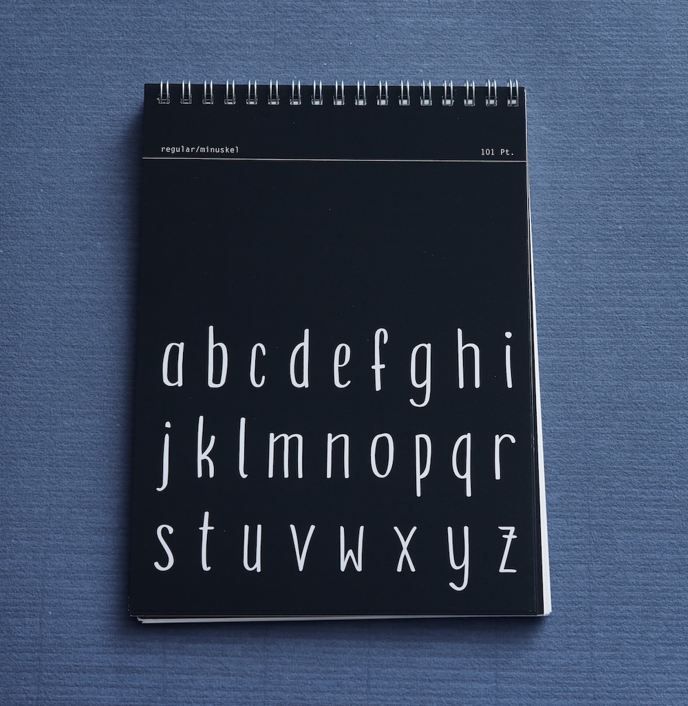 Specimen zur schrift handwerk, man sieht die seite, welche alle kleinbuchstaben des schriftschnitts regular zeigt. weiße schrift auf schwarzem hintergrund