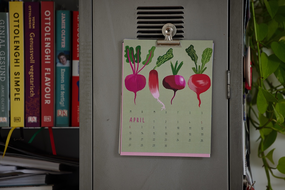 aufgehängter kalender, zeigt monat april mit 4 radiesschen auf grünem hintergrund