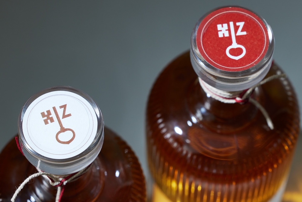 detailaufnahme deckel, einmal roter sticker mit logo (schlüssel und Z verbindung), einmal das gleiche in weiß mit braunem logo